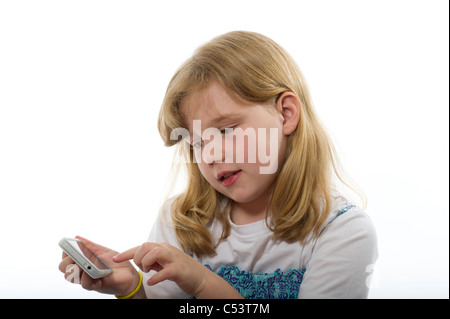 Girl of primary age playing with an iphone/ipod touch against a plain white studio background. Stock Photo