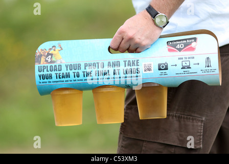 Man carries three pints of Larger in a holder. Picture by James Boardman. Stock Photo