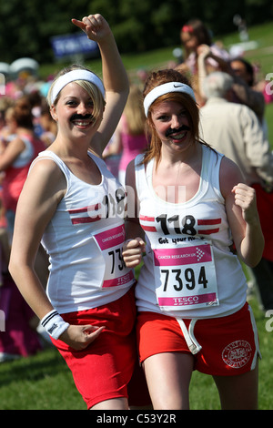 Two young women pictured dressed as 118 118 characters and taking part in Brighton's Race for Life event in Brighton, UK. Stock Photo