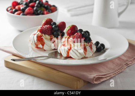 Meringue nests with fruit and cream Stock Photo