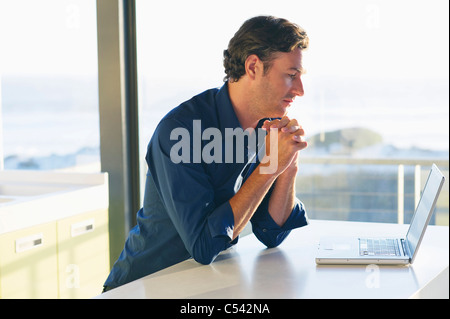 Side profile of a mid adult man looking at a laptop Stock Photo