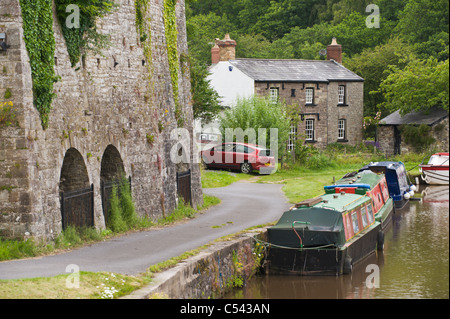 Narrow boats moored next to Victorian lime kiln on Monmouthshire and Brecon Canal near village of Llangattock Powys South Wales Stock Photo