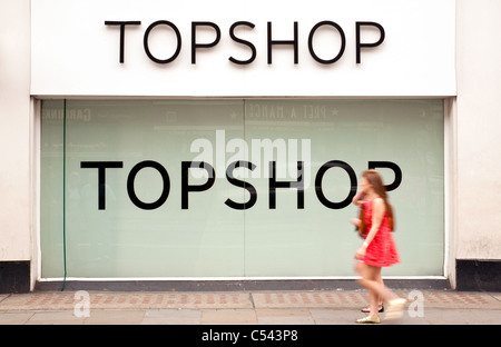 Girls walk past a large Topshop sign, the Strand, London UK Stock Photo