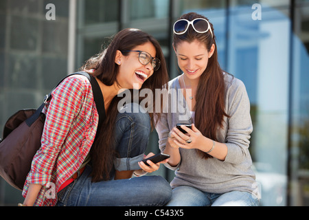Two female friends using mobile phones Stock Photo