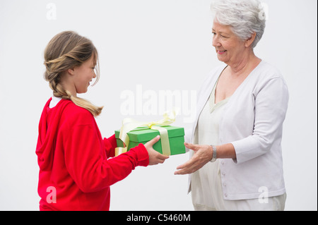 Senior woman giving gift to her granddaughter Stock Photo