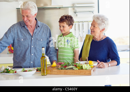 Senior couple preparing food with their grandson Stock Photo