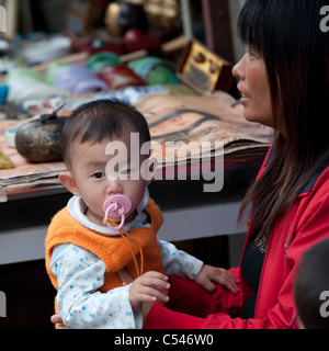 Woman carrying her son, Shanghai, China Stock Photo