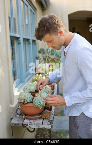 Profile of man holding potted plant and smiling Stock Photo - Alamy