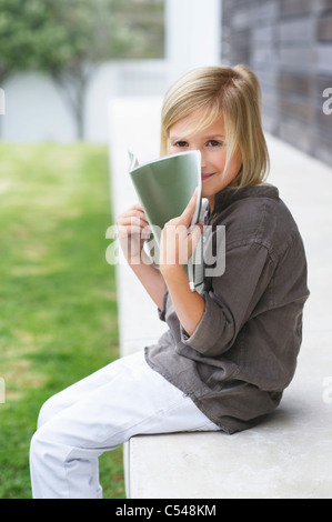 Portrait of girl holding book and smiling Stock Photo - Alamy