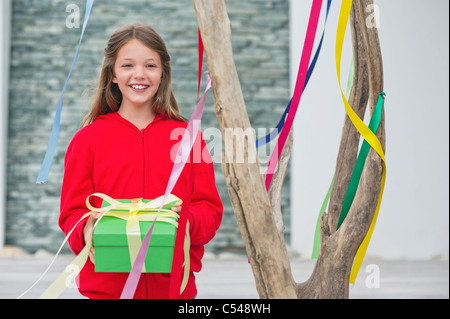 Portrait of a girl holding a gift box and smiling Stock Photo