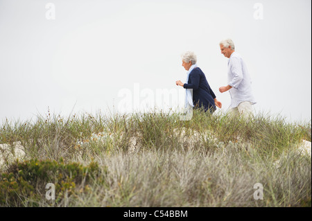Senior couple running on the beach Stock Photo