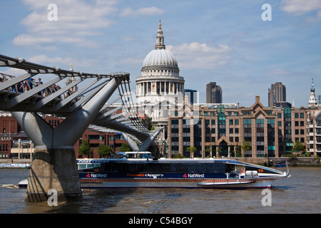 St.Paul's cathedral & Millennium footbridge with Thames clipper passing underneath Stock Photo