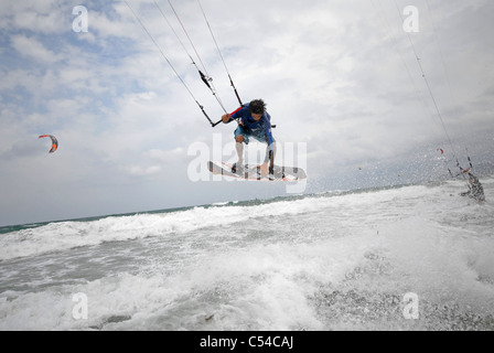 Kite surfer jumping in shallow   white water close to shore Stock Photo