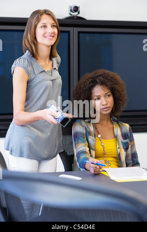 Two female university students giving presentation in a classroom Stock Photo