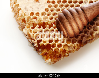 Honeycombs and wooden stick. Isolated on a white background. Stock Photo