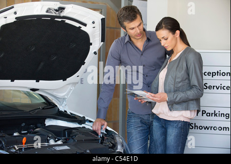 Couple looking at a car catalog in showroom Stock Photo