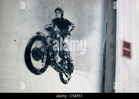 Stencil graffiti on a wall in London featuring the Queen riding a motorbike Stock Photo