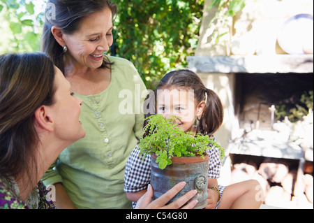 Multi generation family smelling a potted plant Stock Photo