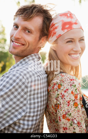 Portrait of a couple standing back to back and smiling Stock Photo