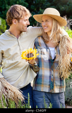 Young couple in scarecrow pose in a field Stock Photo