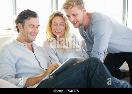 Mid adult man using a digital tablet and smiling Stock Photo