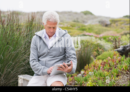 Senior man using a digital tablet Stock Photo