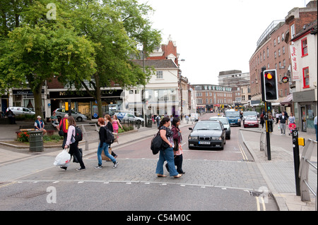 People crossing a pedestrian crossing whilst the traffic lights are on red in Norwich city centre, England. Stock Photo