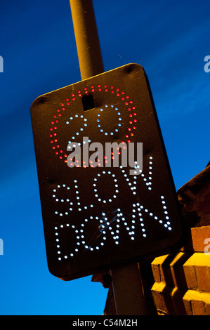 Illuminated road safety sign showing speed limit of 20 miles per hour on a road in England. Stock Photo