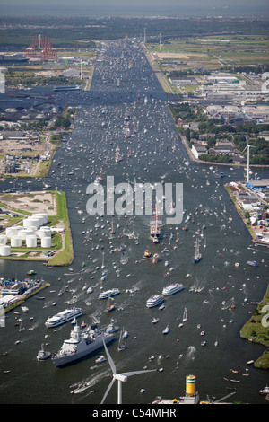 Aerial of parade of tall ships from IJmuiden to Amsterdam through canal called Noordzeekanaal. View on Amsterdam harbour. Stock Photo