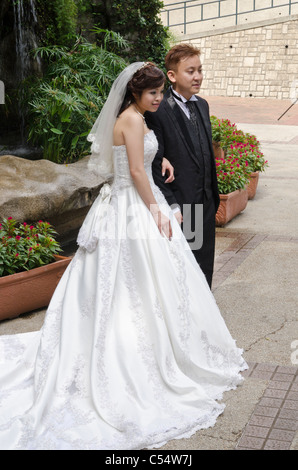 Wedding couple posing for wedding photos in Kowloon Park, Hong Kong Stock Photo