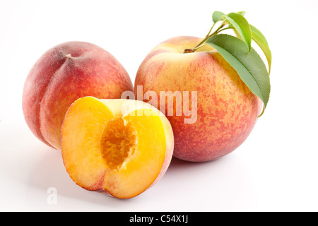 Ripe peach fruit with leaves and slices on white background. Stock Photo