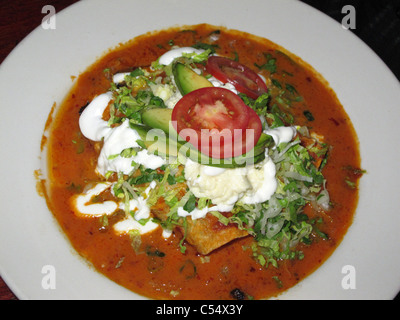 Mexican Food Enchiladas with Red Salsa, tomatoe, Guacamole and Avocado. Typical food from Mexico Stock Photo