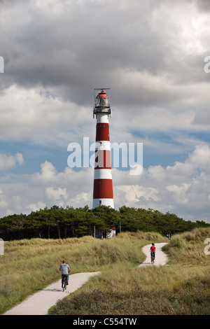 Holland, Ameland Island, Wadden Sea Islands. Unesco World Heritage Site. Hollum, Lighthouse. People on bicycle on beach road. Stock Photo