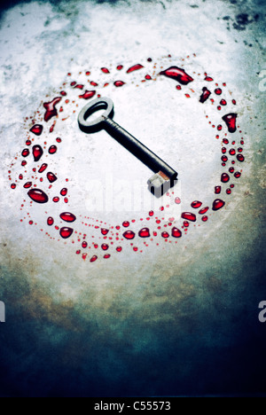 Old rusted key in a circle of blood Stock Photo