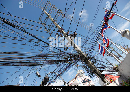 Telegraph poles and dangerous tangled mass of electricity wires and wiring, a health and safety danger in Phuket, Thailand Stock Photo