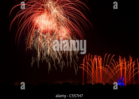 Walt Disney World Magic Kingdom Fireworks high in sky panoramic view from Grand Floridian Resort blue light on small Cinderella's Castle adds scale Stock Photo