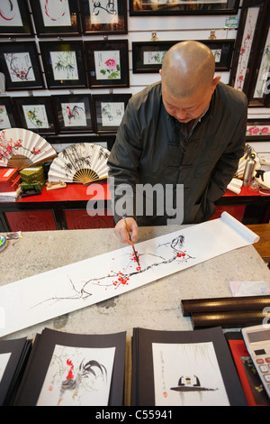 Artist painting a traditional artwork in a store, Silk Market, Beijing, China Stock Photo