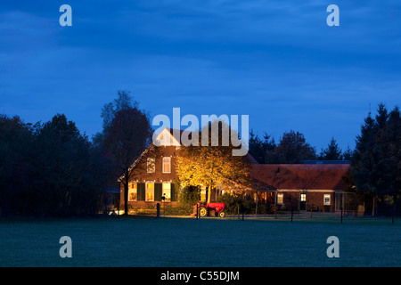 The Netherlands, Winterswijk, Autumn colours, trees, Farm and old tractor in floodlight. Stock Photo