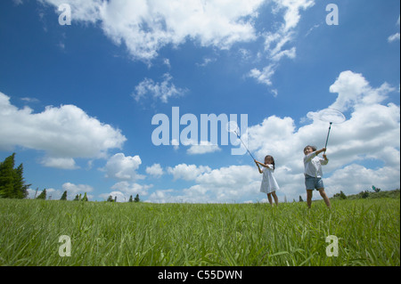 A boy and a girl holding butterfly catcher Stock Photo