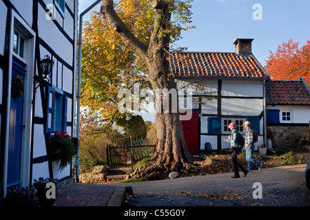 The Netherlands, Epen, Frame houses. Tourists hiking. Stock Photo