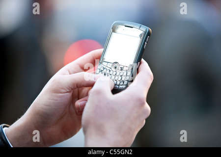 Person texting on smart  phone in public Stock Photo