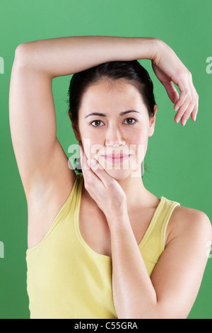 Woman posing and smiling while touching her head Stock Photo - Alamy