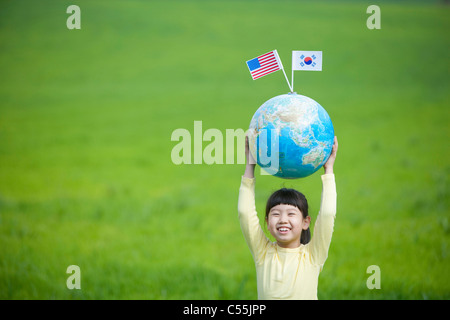 girl raised globe and flags in her hands Stock Photo
