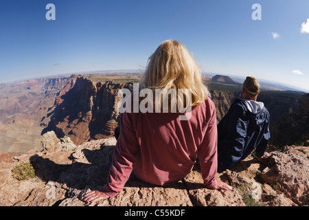Tourist couple sitting on Canyon Rim, Desert View, Grand Canyon National Park, Arizona Stock Photo