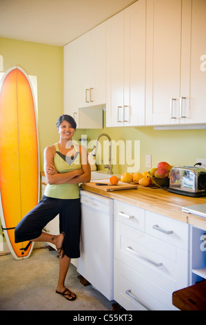 Young woman practicing yoga in kitchen Stock Photo