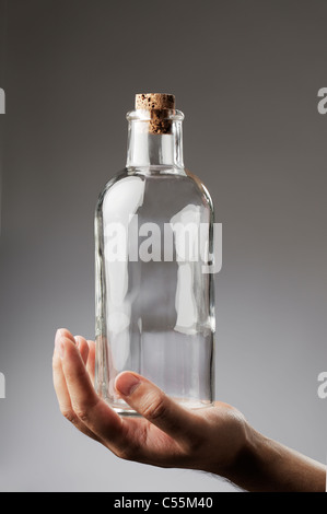 Man holding an old-fashioned glass bottle in his hand. Stock Photo