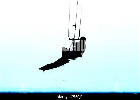 Kite surfer in action jumping, silhouetted Stock Photo