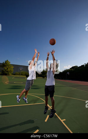 jump shot during two on two basketball game being defended Stock Photo