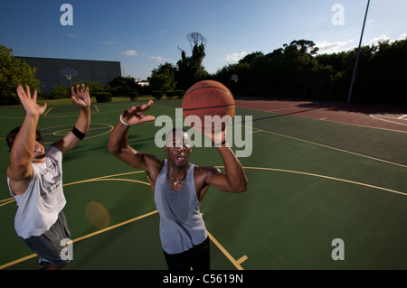 males playing outdoor basketball game Stock Photo