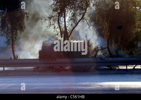 Smoldering remains of US Personnel Carrier damaged by Rocket Propelled Grenade close to Baghdad city, Iraq, Middle East Stock Photo